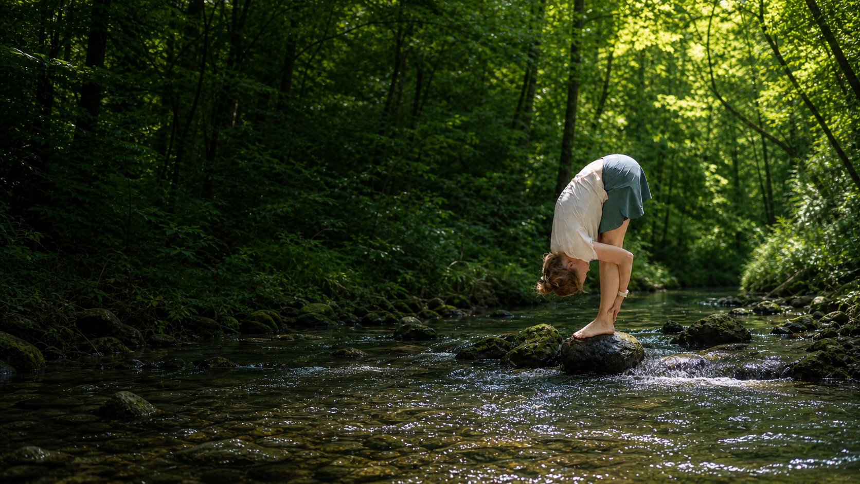 Masha practising yoga beside a forest stream